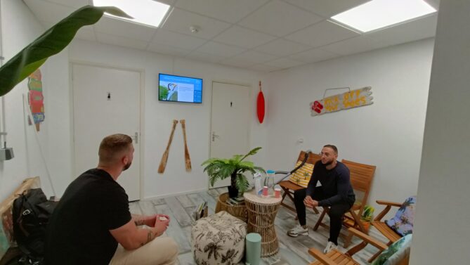 twee mensen die kijken naar digitale signage van zenderbaas